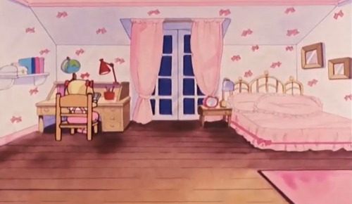 Rolley's Room, with white walls decorated with painted pink bows, a tall window with light pink curtains, a bed with two large, frilly light pink pillows and frilled pink sheets with a darker pink ribbon all around. She has a wooden bedside table with a round, dark pink clock and a wooden desk & chair in the opposite corner of the room from the bed. The desk has a globe and red lamp. On the wall next to the desk, there's a white shelf with books. Two framed pictures hang on the wall next to the bed. A pink rug rests on a small corner of the wooden floor.